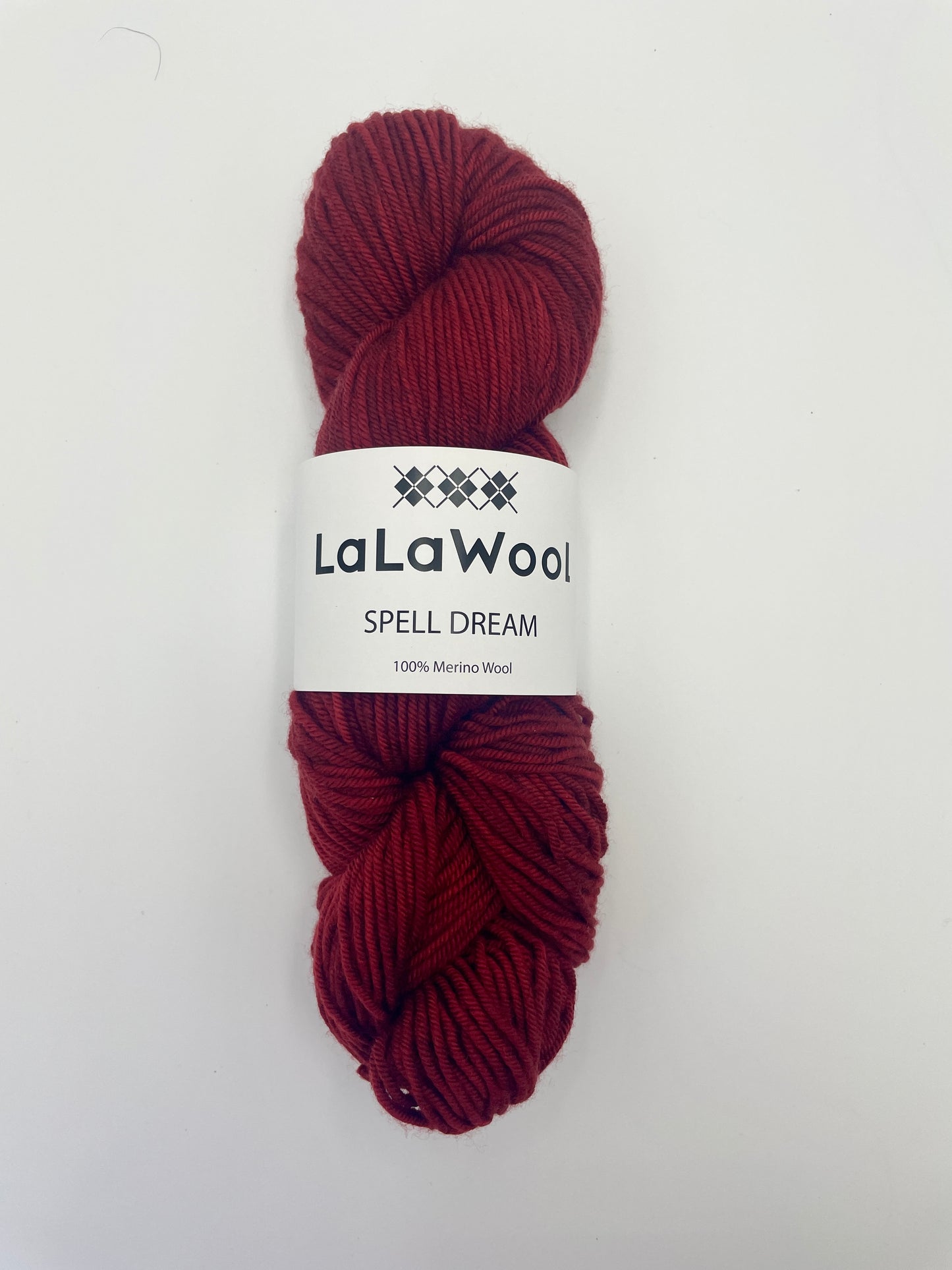 100% Australian Merino Spell Dream Worsted Yarn in Red Bordeaux Colour, top view of one skein with LaLaWool tag