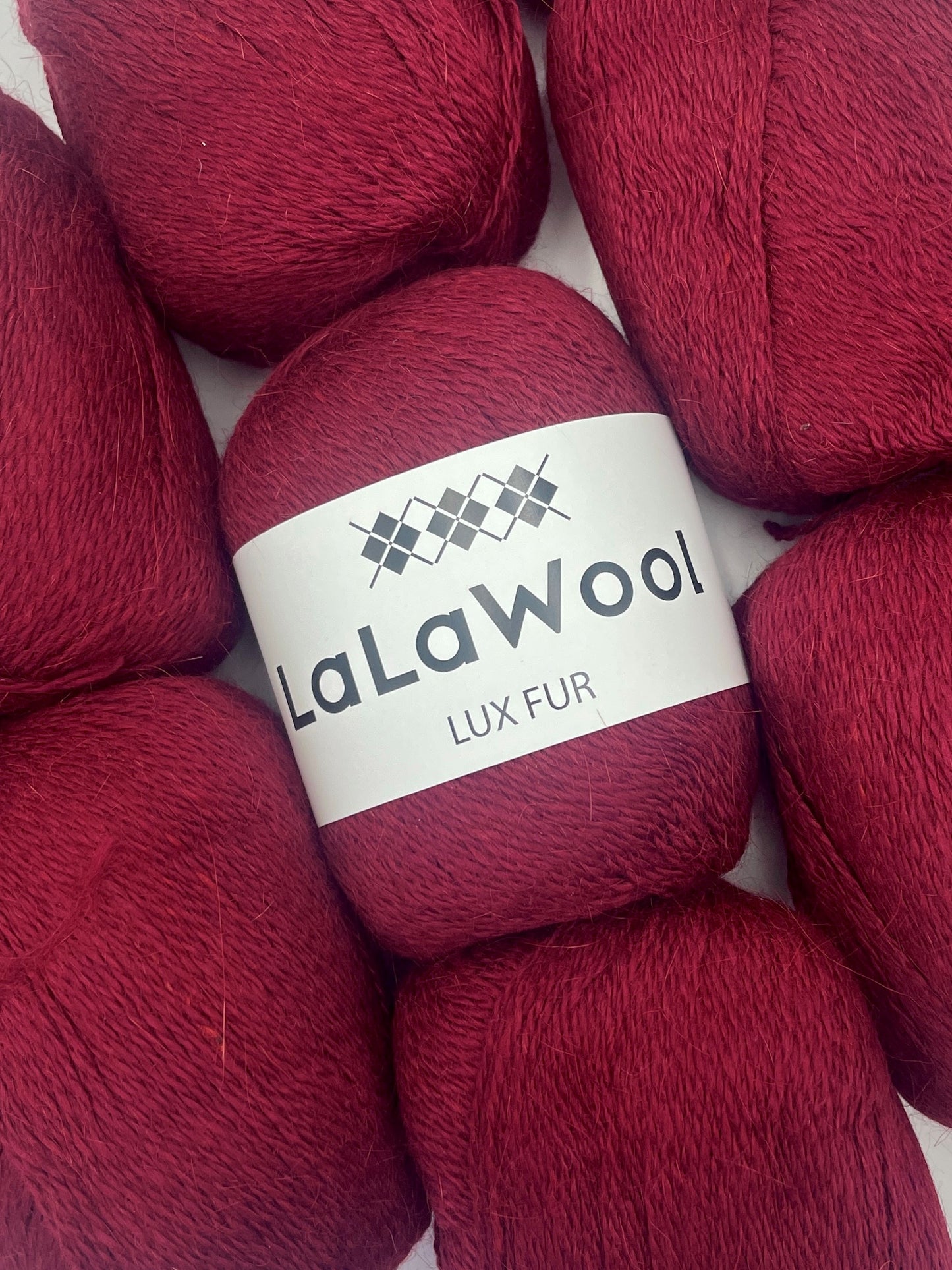 Angora Fingering Yarn Lux Fur in Burgundy Red Colour, top view with multiple skeins with LaLaWool tag, white background